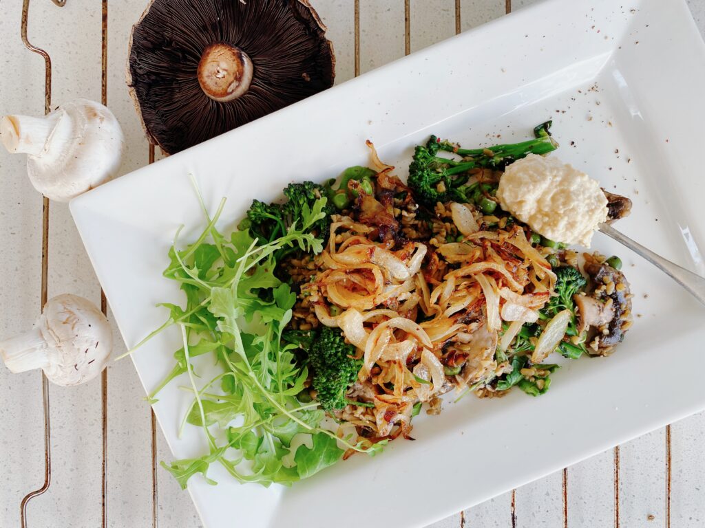 A plate of food with mushrooms and greens on it.