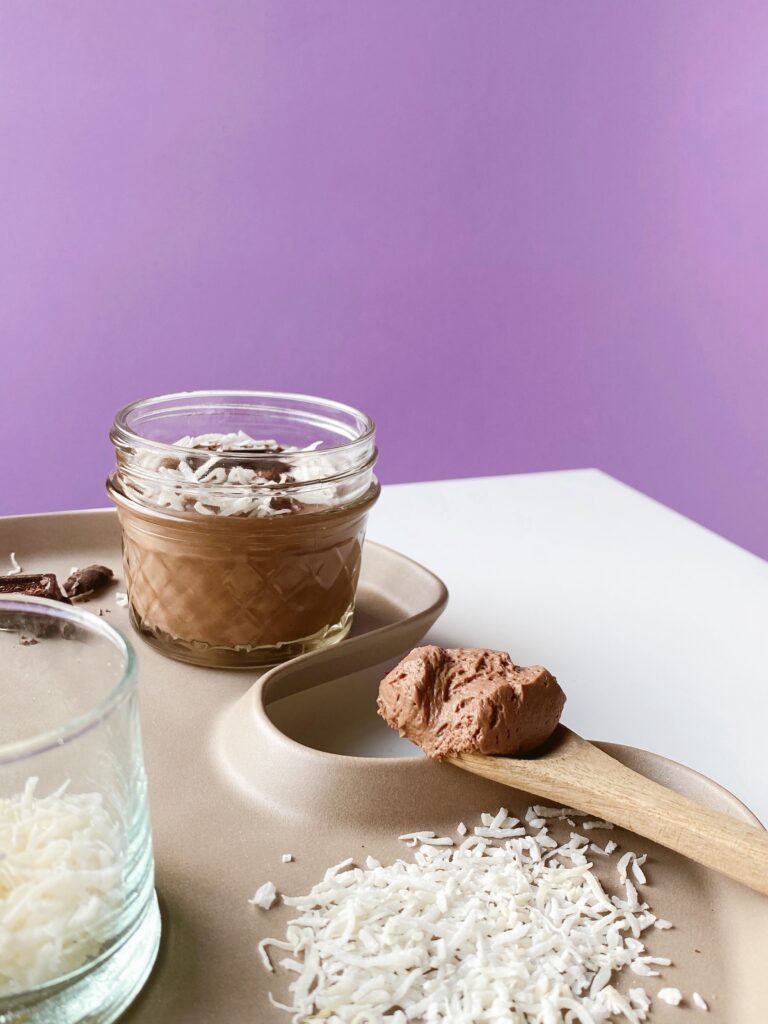 Chocolate mousse in jars on a purple plate.