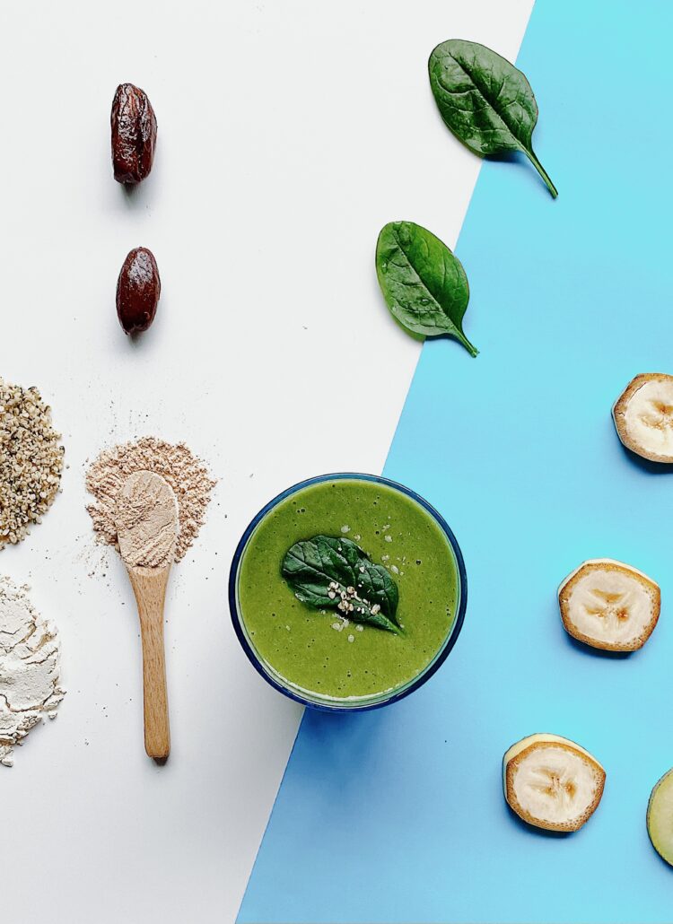 A tall glass filled with a vibrant green smoothie is placed on a table. The smoothie is made with fresh ingredients, including ginseng, kiwifruit, dates, and chia seeds. The drink is topped with a sprinkle of chia seeds and a sliced kiwifruit on the rim of the glass. The green color of the smoothie hints at the abundance of nutritious leafy greens blended into the mixture. The image exudes a sense of health, vitality, and natural goodness, inviting viewers to explore the delicious and energizing recipe.