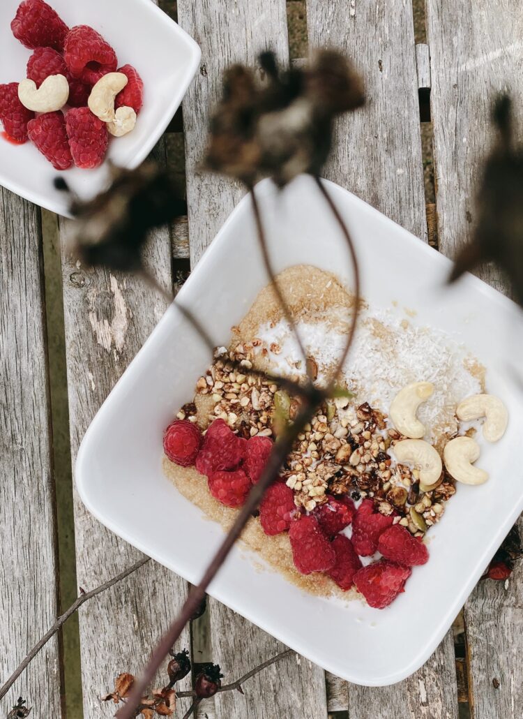 An image of a beautifully arranged bowl filled with cooked amaranth grains topped with a generous serving of fresh, vibrant raspberries. The bowl is placed on a rustic wooden table, creating a visually appealing and appetizing scene. The combination of the nutritious amaranth and juicy raspberries showcases a wholesome and delicious breakfast or snack option. The image captures the essence of healthy eating and natural ingredients, making it an excellent choice for promoting the benefits of this superfood dish.