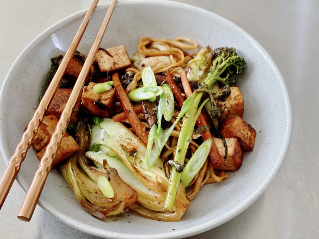 A vibrant and enticing stir-fry showcasing tofu, vegetables, and yakisoba noodles. Indulge in this nutritious and delectable vegan meal, abundant in plant-based protein and bursting with Asian-inspired flavor