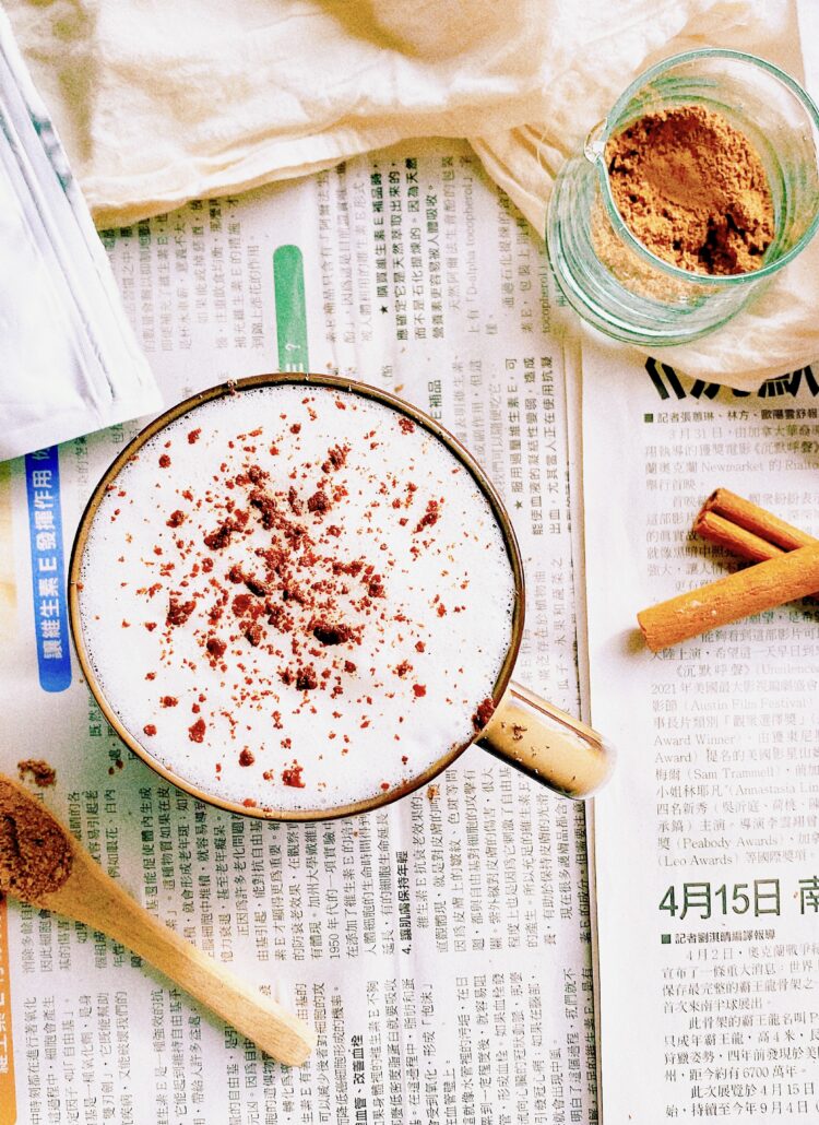 A cup of reishi mushroom latte on a newspaper.